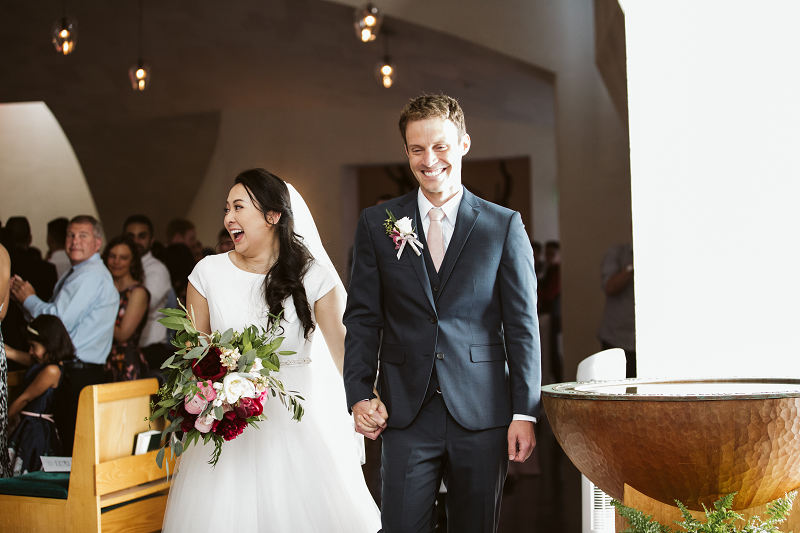 a happy couple processes out of the Chapel after their wedding. 